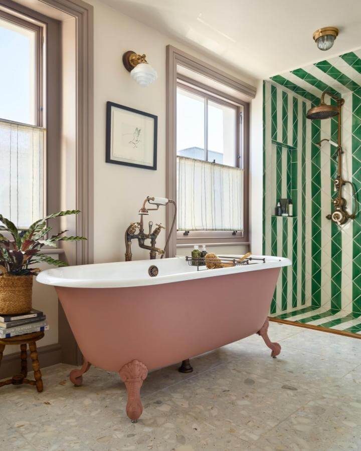 Muted pink clawfoot tub and green tiled shower in Victorian bathroom ideas by @drummonds_bathrooms soft natural light and classic details.