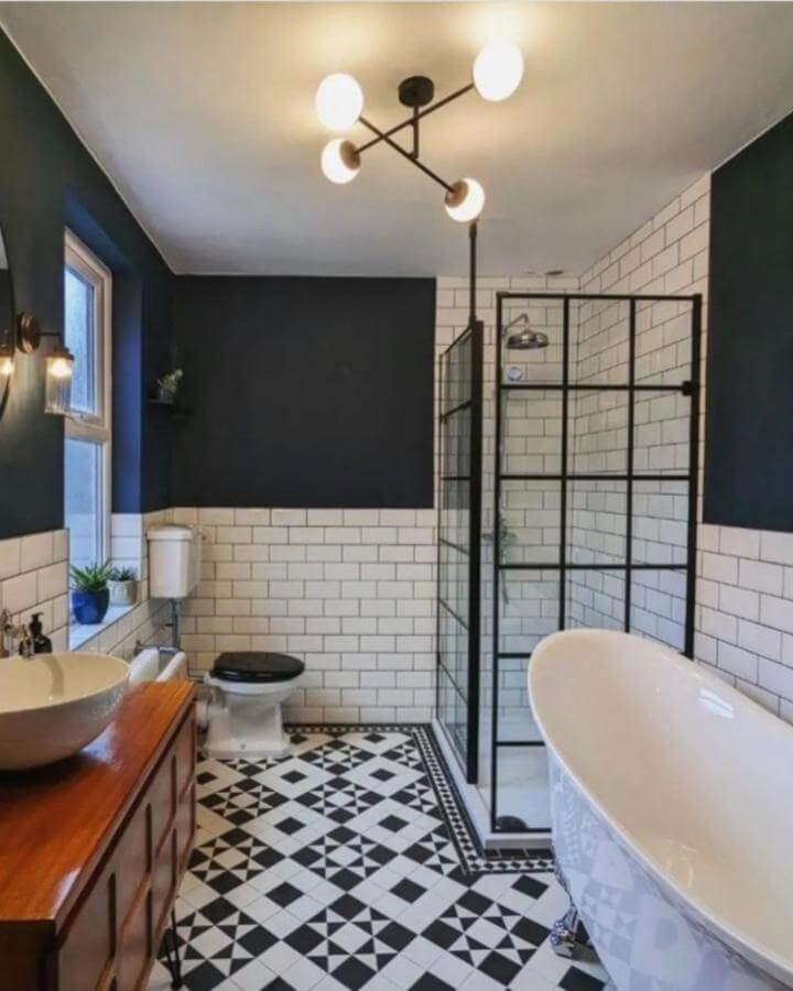 Black and white checkerboard floor tiles in Victorian bathroom with navy walls and clawfoot tub from @bathroommountainuk. Classic victorian bathroom ideas style.
