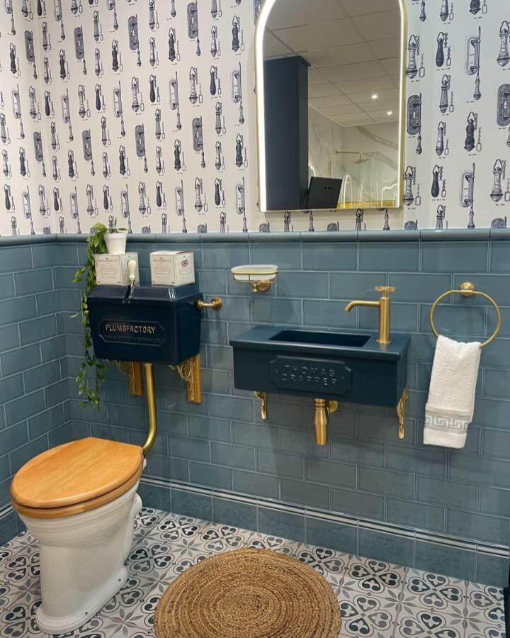 Navy blue fixtures with gold accents in a Victorian bathroom ideas setting by @plumbfactory_horwich featuring patterned tiles and vintage-inspired wallpaper.