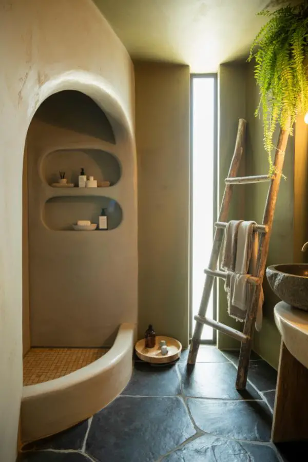 Curved cream plaster storage niches in earthy bathroom with natural textures and organic architectural details.