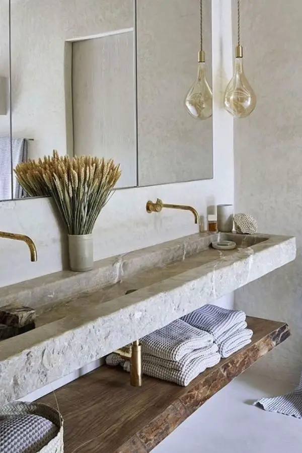 Raw limestone vanity from @arq.constanzadel featuring natural imperfections perfect for wabi sabi bathroom ideas.