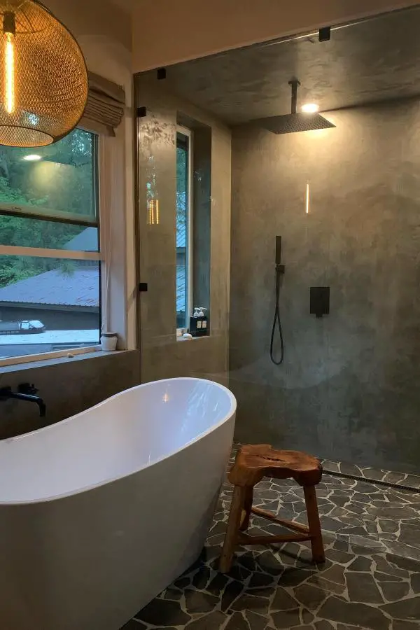 Modern concrete bathroom featuring natural textures and organic materials with imperfect surfaces.