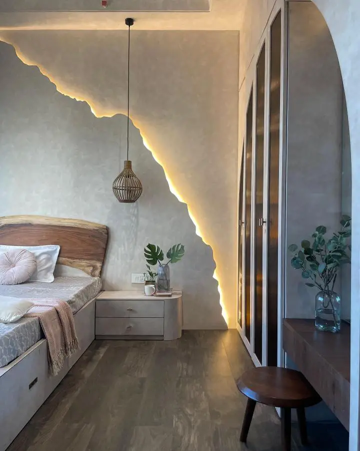 Curved LED lighting installation from @brick.rug_interiordesign. Warm illuminated waves against textured grey walls create organic bedroom ambiance.