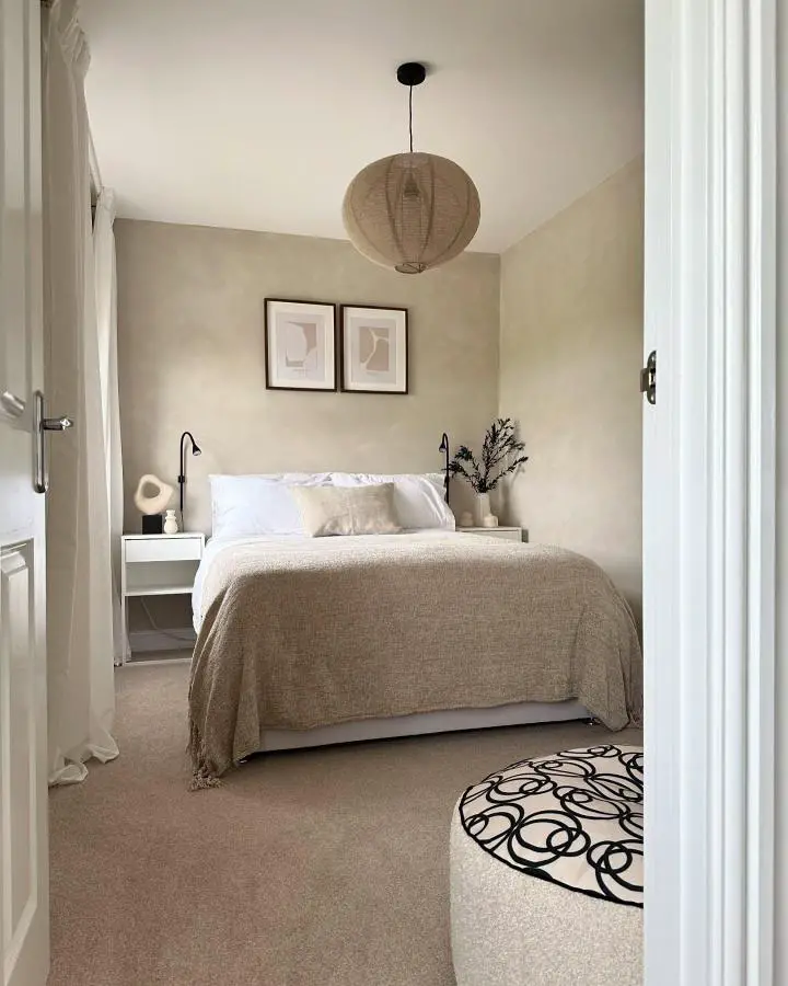 Neutral bedroom with woven pendant light from @the_welham. Beige walls and natural textures create calm atmosphere.