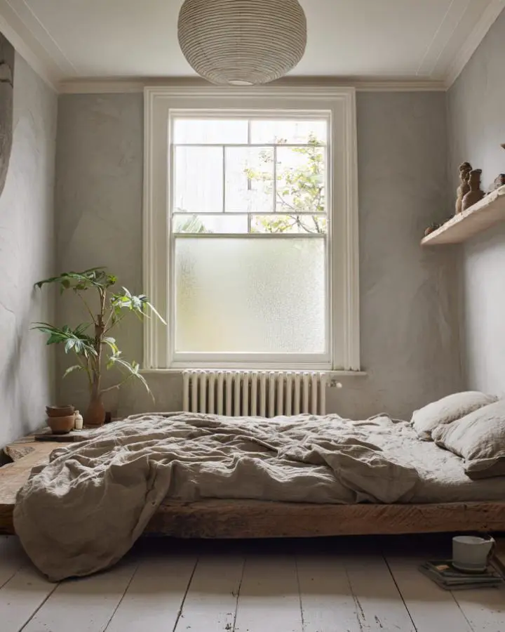 Cozy unmade bed with natural linen bedding showcasing wabi sabi bedroom ideas in serene neutral space.