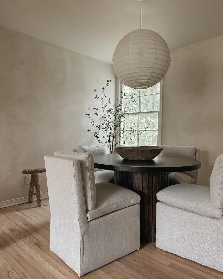 Oversized cream paper lantern pendant from @cozy.happy.home. Creates sculptural focal point above dark wood dining table.