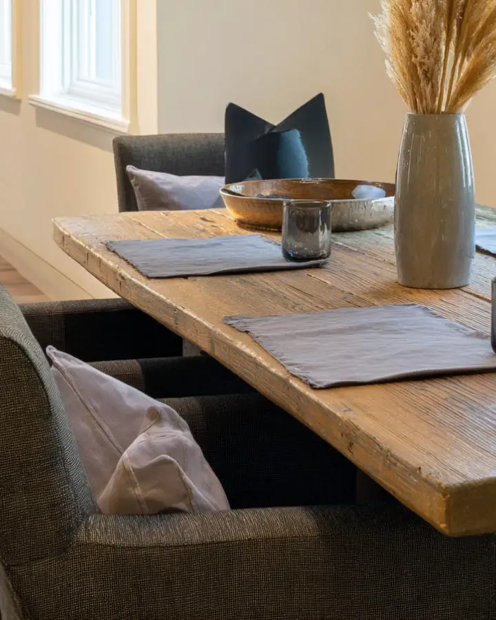 Rustic wooden dining table with natural grain patterns and weathered edges showing authentic character.