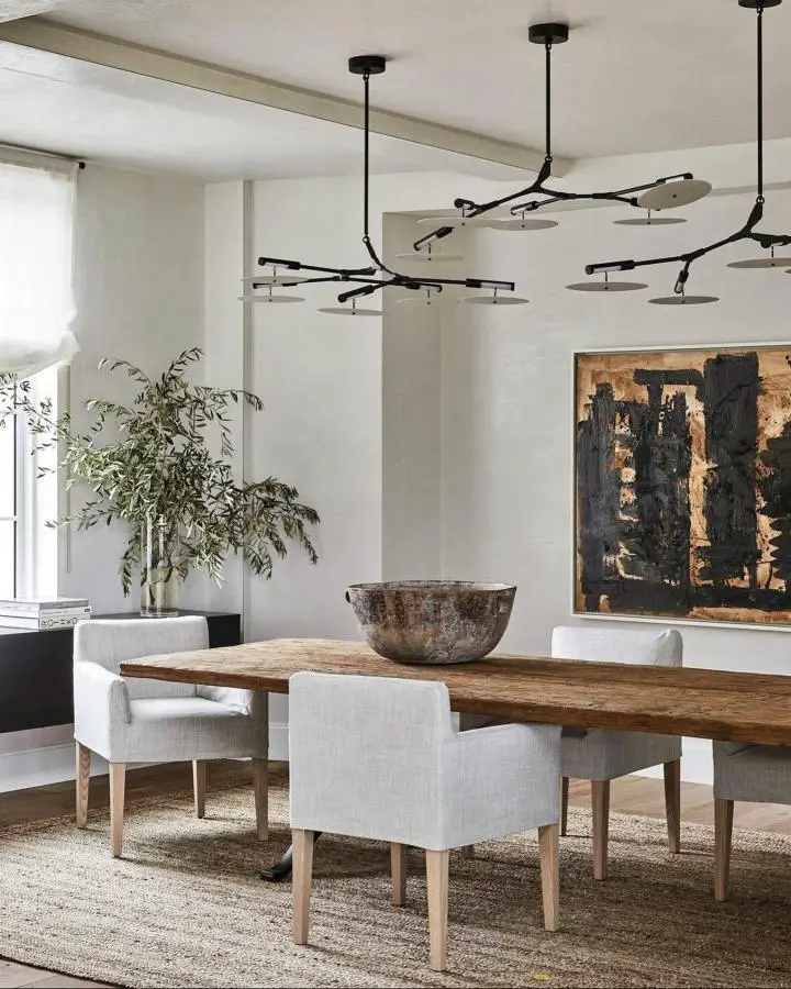 Black branch-style chandelier from @demiurgenewyork. Multiple pendant lights create organic asymmetrical lighting design.