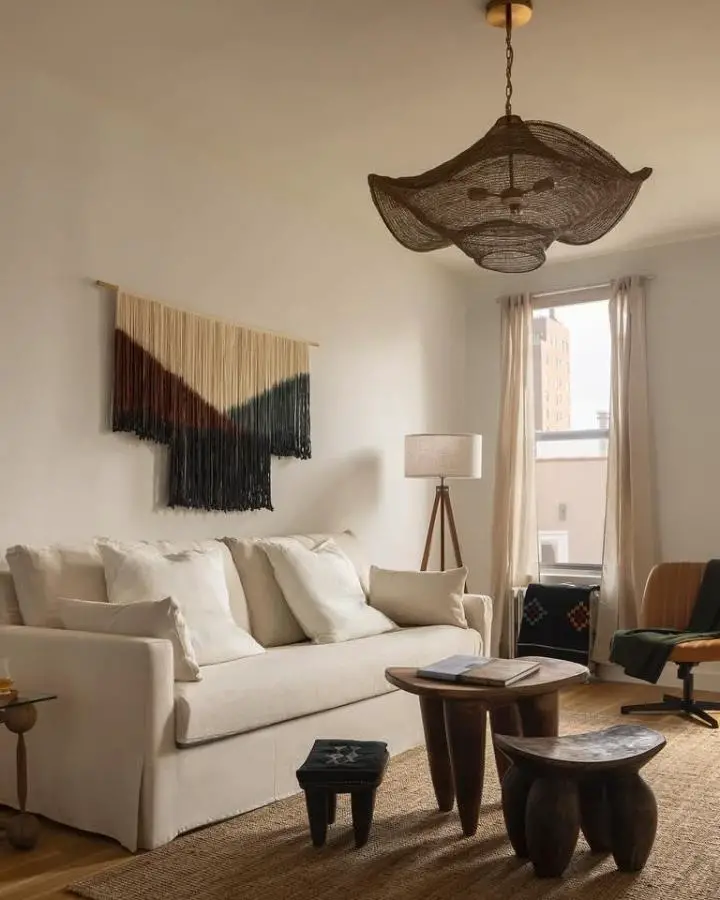 Oversized woven rattan pendant light from @tnbarchitecture. Natural basket-style fixture hangs above neutral living space.