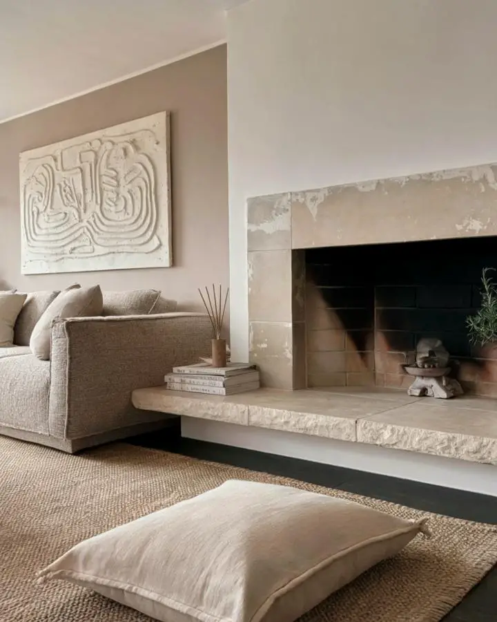 Weathered limestone fireplace hearth featuring natural imperfections and aged patina. Neutral living space with textured stone surround.