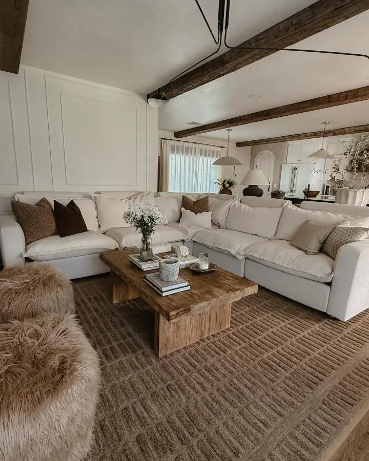 Rustic wooden beam ceiling with white sectional sofa showcasing wabi sabi living room ideas from @kristinanevans. Natural textures and neutral tones create authentic imperfection.