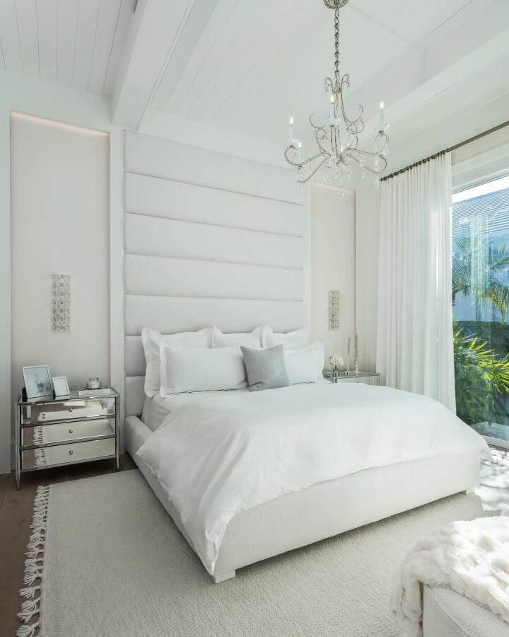White layered textured bedroom by @hummingbird_home_design featuring plush upholstered headboard and mirrored nightstands in white aesthetic bedroom ideas.