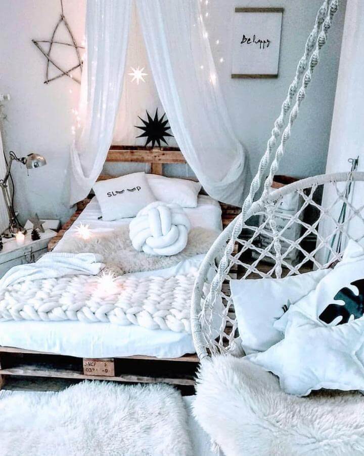 White layered textures bedroom with chunky knit blanket and hanging chair from @my.millennium.maison. Cozy and serene vibe.