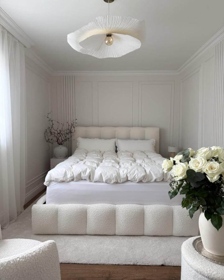 White plush textured bed and soft rug with floral accent from @theinteriorslady in a serene, elegant bedroom setting.