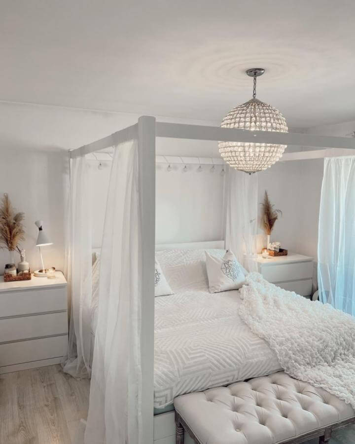 White canopy bed with sheer curtains and textured bedding from @morricehome showcasing cozy white aesthetic bedroom ideas.