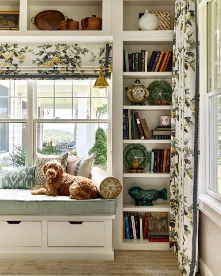 Light pastel green cushioned window seat ideas from @kristenmccory with floral curtains, pillows, and built-in storage drawers.