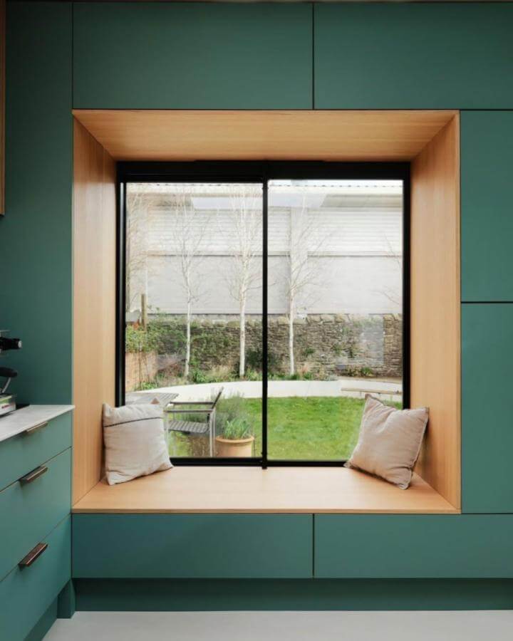 Light wood framed kitchen nook from @madebyhusk featuring teal cabinetry and minimalist cushions. Cozy and inviting sitting area.