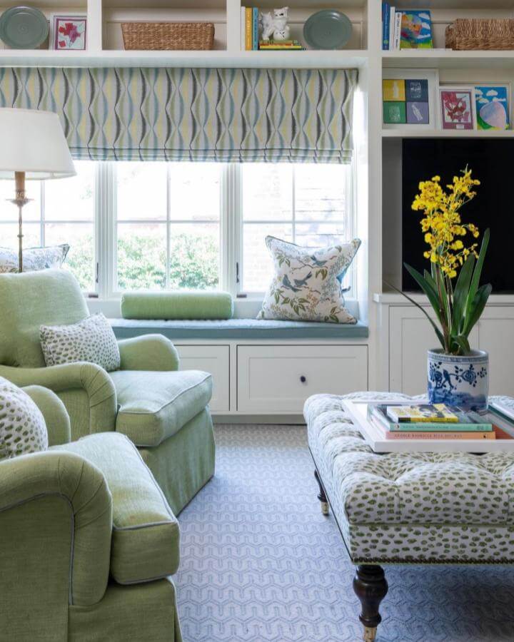 Soft green cushioned window nook from @ashleygoforth with leafy pillows and patterned roman shade creating a cozy reading corner.