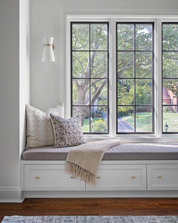Light neutral window seat with cushions and storage drawers from @nataliefogelstrom featuring soft textures and wood floor window seat ideas.