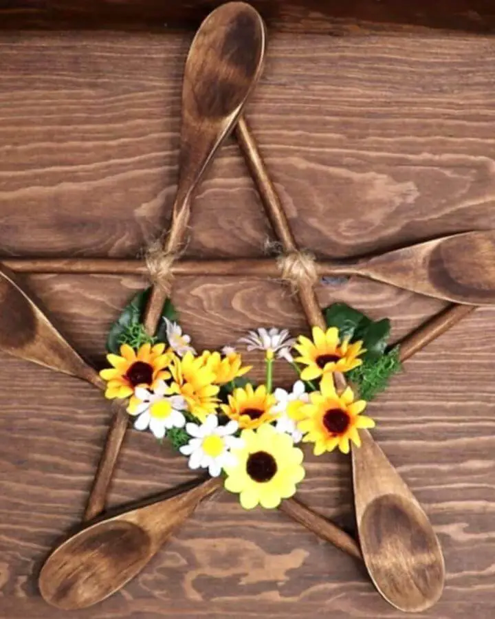 Wooden spoon pentagram wreath from @serenityonesanctuary. Yellow sunflowers and white daisies accent natural wood star shape.