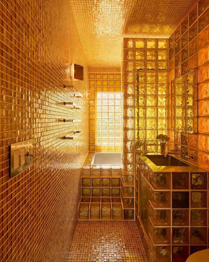 yellow glass block bathroom with mosaic tiles from @ch_herrero warm glowing yellow bathroom ideas with reflective surfaces and glass blocks