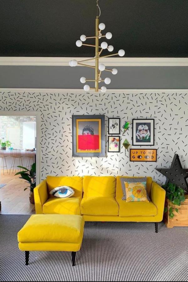 Vibrant yellow wallpaper accents in a cozy living room from @comedowntothewoods on @sofadotcom, highlight bold interior designs.